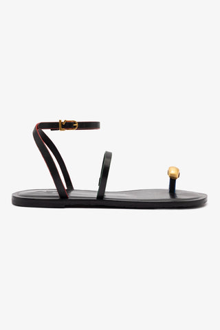 A black flat sandal with gold hardware and an adjustable ankle strap, featuring a memory foam cushioned insole and a round open toe.